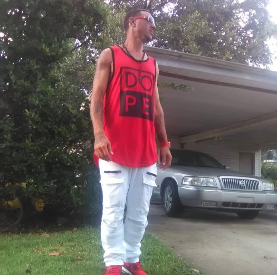 Butch standing outside in a red shirt